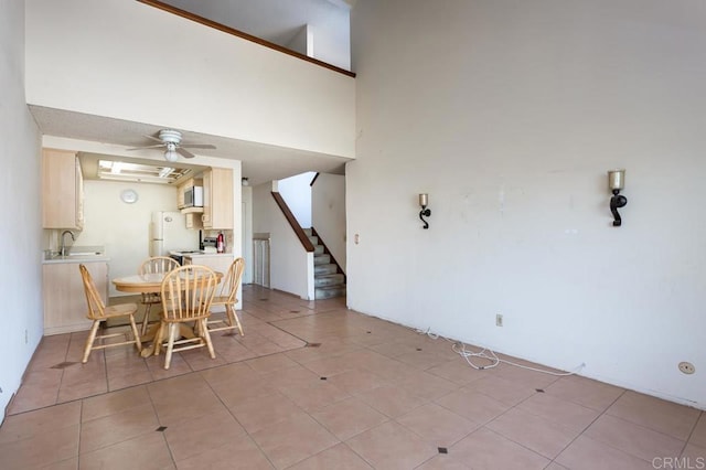 dining area featuring a high ceiling, sink, and ceiling fan