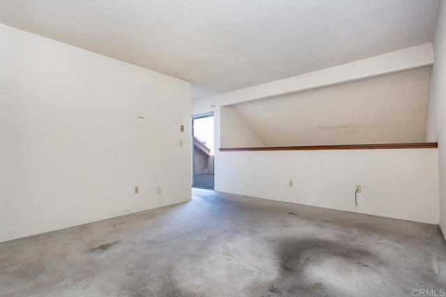 additional living space with beam ceiling and a textured ceiling