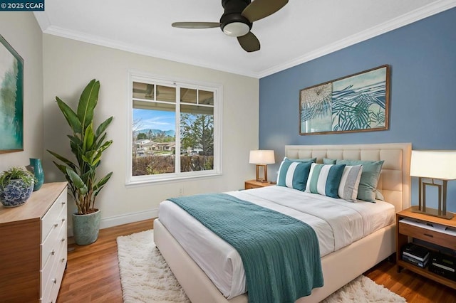 bedroom featuring crown molding, wood-type flooring, and ceiling fan