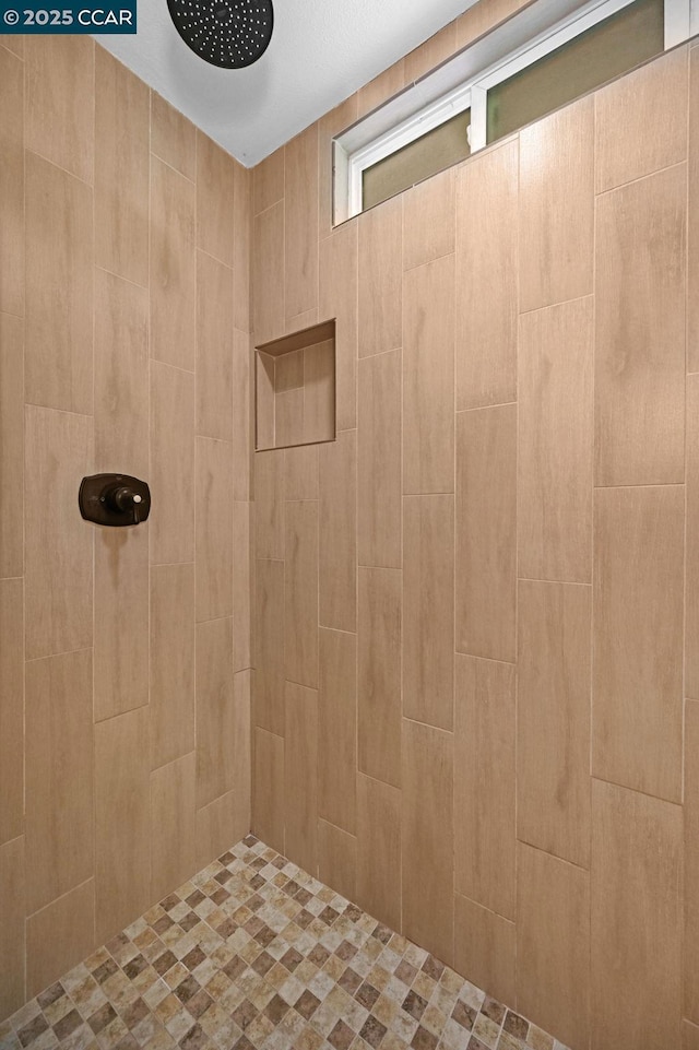 bathroom with a tile shower