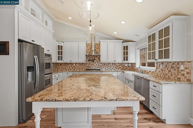 kitchen with lofted ceiling, white cabinets, hanging light fixtures, a center island, and stainless steel appliances