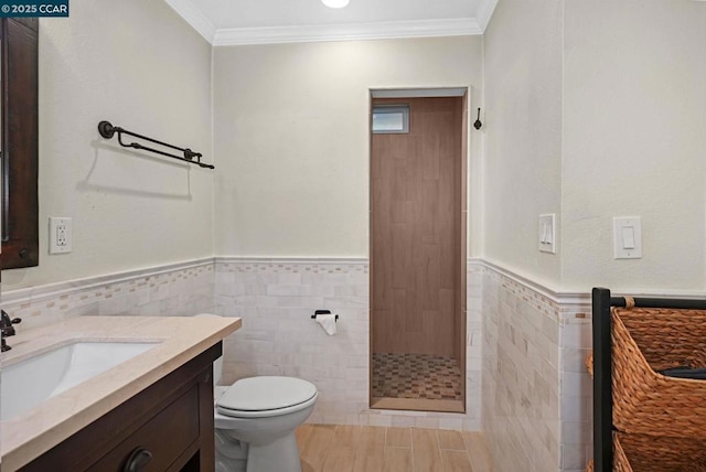 bathroom featuring walk in shower, toilet, tile walls, ornamental molding, and vanity