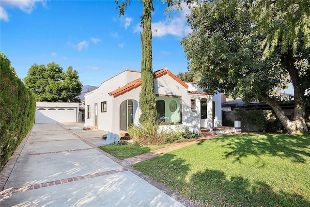 mediterranean / spanish home featuring a garage and a front yard