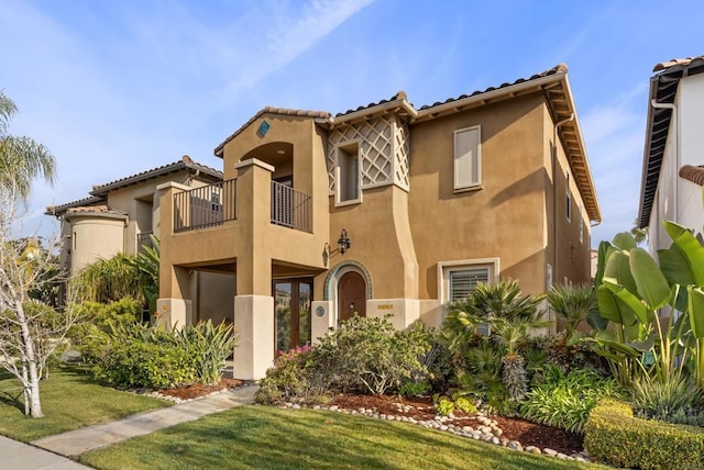 mediterranean / spanish-style home with a balcony and a front lawn