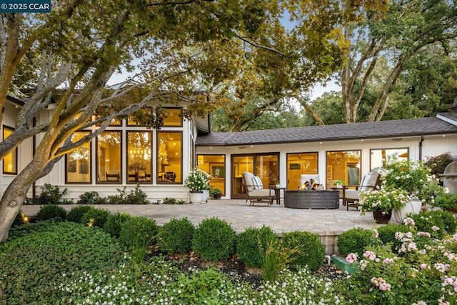 rear view of property with a patio and outdoor lounge area