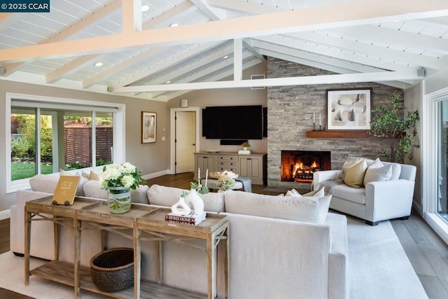 living room with hardwood / wood-style flooring, a fireplace, and lofted ceiling with beams