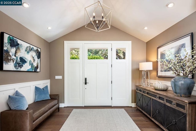 foyer featuring lofted ceiling, dark hardwood / wood-style floors, and a notable chandelier