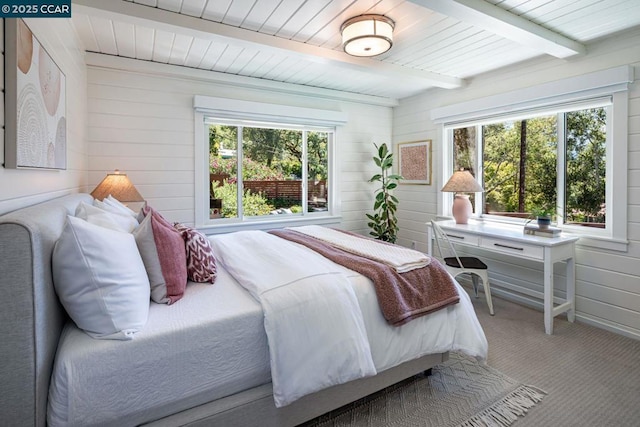 bedroom with carpet floors and beamed ceiling