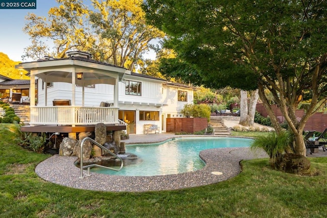 view of swimming pool with a wooden deck and a yard