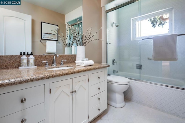 full bathroom with enclosed tub / shower combo, vanity, toilet, and tile patterned flooring