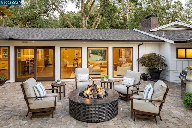 view of patio with a grill and an outdoor living space with a fire pit