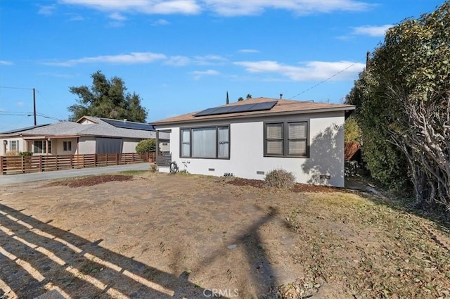 rear view of property featuring solar panels