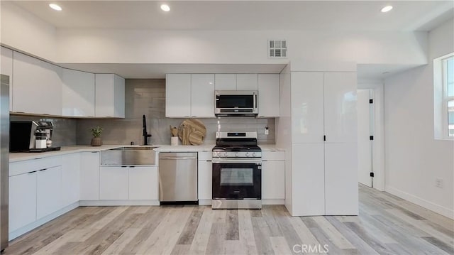 236 N Burlington, Los Angeles, CA 90026 - kitchen featuring stainless steel appliances, light wood-type flooring, backsplash, white cabinets, and recessed lighting