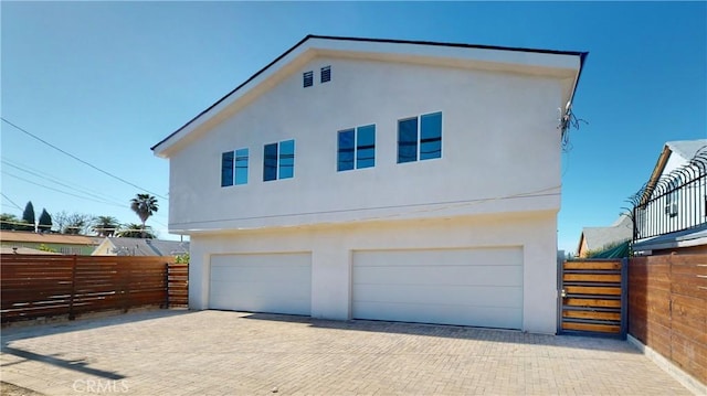 236 N Burlington, Los Angeles, CA 90026 - view of home's exterior featuring a garage, stucco siding, and decorative driveway