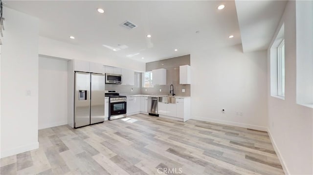 236 N Burlington, Los Angeles, CA 90026 - kitchen with appliances with stainless steel finishes, light wood-style flooring, light countertops, recessed lighting, and white cabinets