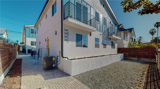 view of side of property with cooling unit and a patio area