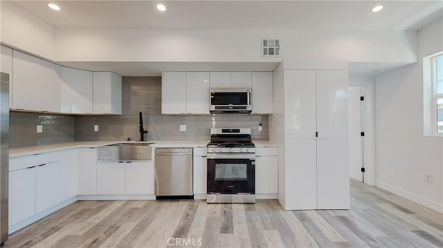 236 N Burlington, Los Angeles, CA 90026 - kitchen featuring stainless steel appliances, light wood-style flooring, light countertops, decorative backsplash, and recessed lighting
