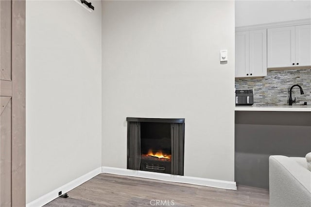 details with sink, decorative backsplash, and hardwood / wood-style flooring