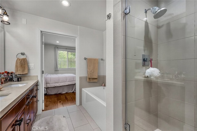 bathroom featuring vanity, plus walk in shower, and tile patterned flooring