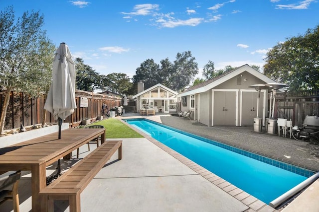 view of pool featuring a shed and a patio area