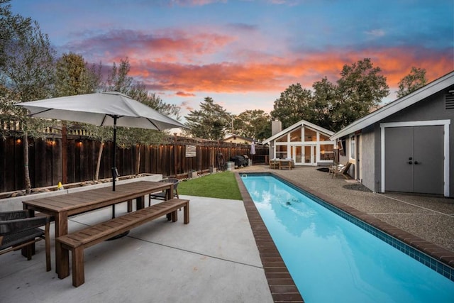 pool at dusk with a patio