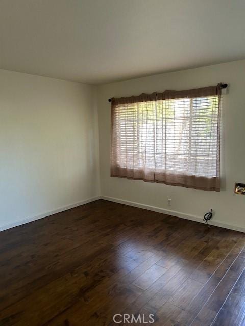 unfurnished room with dark hardwood / wood-style flooring