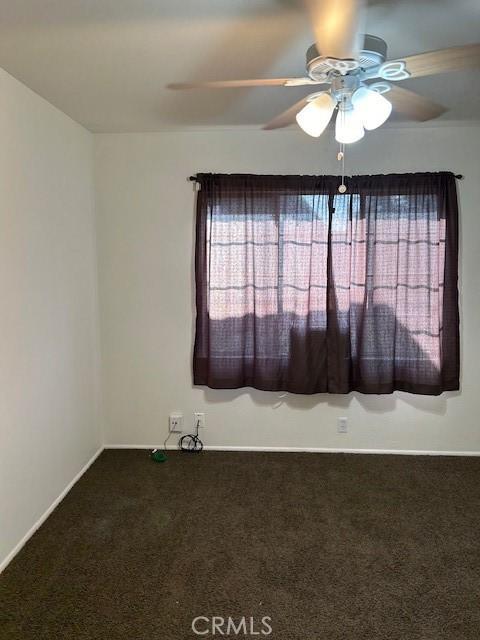 spare room featuring carpet floors and ceiling fan