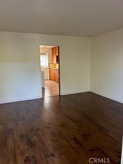 empty room with dark hardwood / wood-style flooring