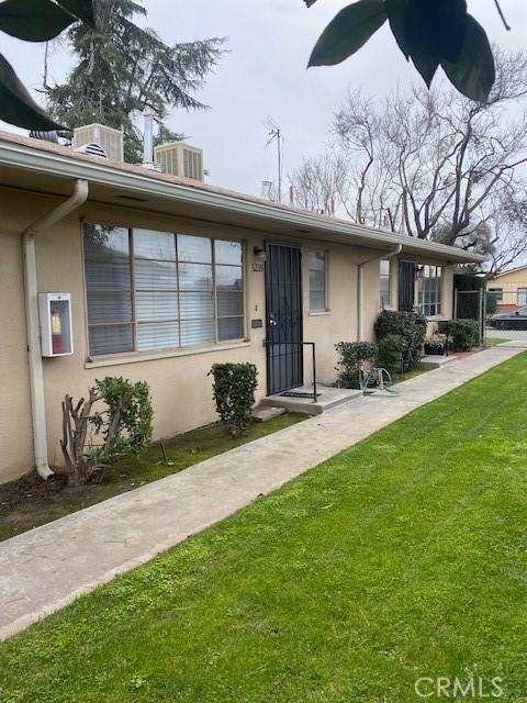 view of front of house with a front yard, central AC unit, and ceiling fan