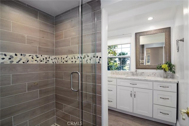 bathroom featuring vanity, wood-type flooring, and walk in shower