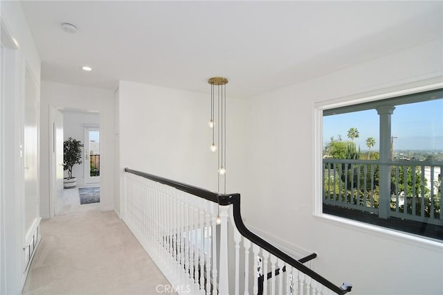 hall with plenty of natural light and light carpet