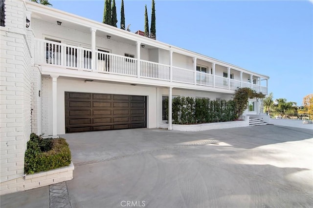 view of front of property featuring a balcony and a garage