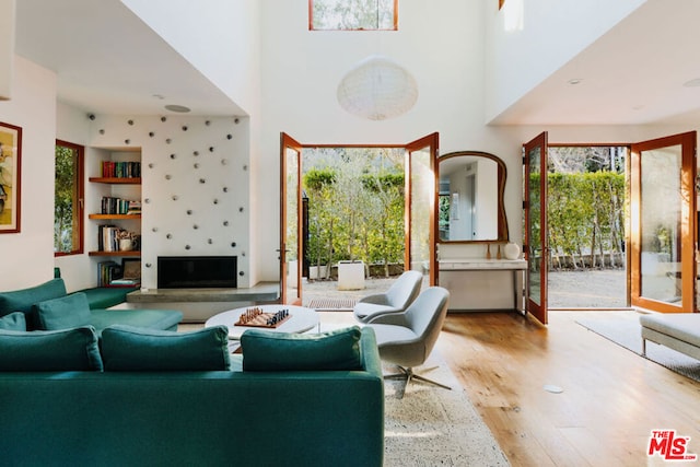 living room featuring light hardwood / wood-style flooring and a high ceiling