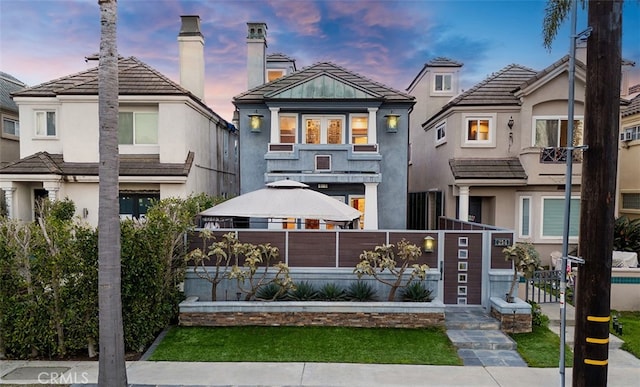 view of front facade featuring a fenced front yard and stucco siding