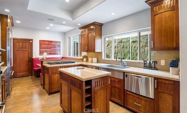 kitchen with appliances with stainless steel finishes, recessed lighting, a kitchen island, and a sink