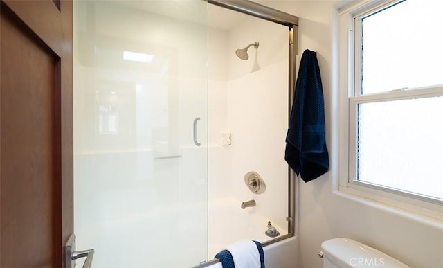 full bathroom with toilet and bath / shower combo with glass door