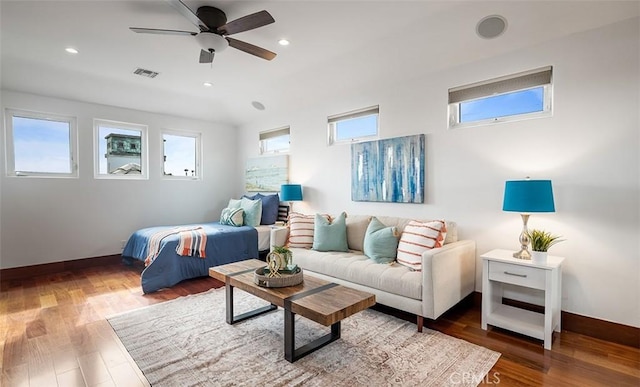 bedroom featuring multiple windows, wood finished floors, visible vents, and baseboards