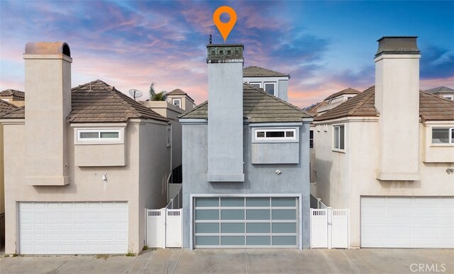 214 Utica Ave, Huntington Beach, CA 92648 - back of property with stucco siding, a chimney, a garage, and a tiled roof