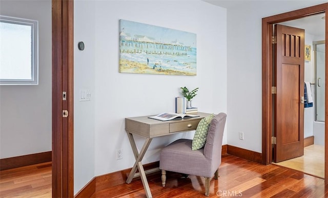 office area with light wood-style floors and baseboards