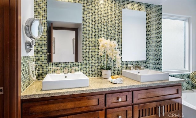 bathroom with double vanity, backsplash, and a sink