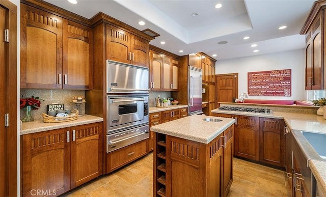 kitchen with a center island, a warming drawer, recessed lighting, appliances with stainless steel finishes, and brown cabinetry