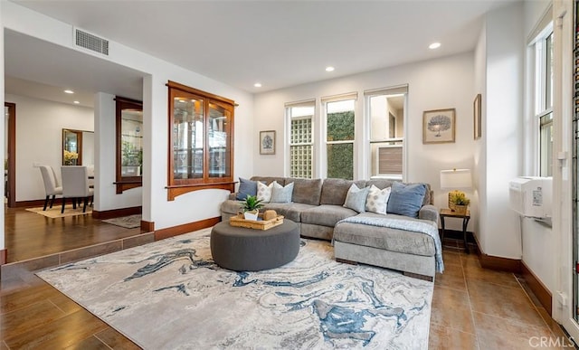 living area with recessed lighting, visible vents, baseboards, and wood finished floors