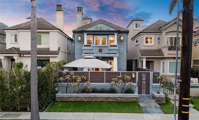 view of front of house with a fenced front yard and stucco siding