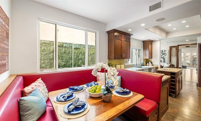 dining space with breakfast area, wood finished floors, visible vents, and recessed lighting