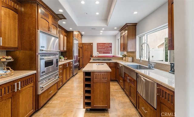 kitchen featuring appliances with stainless steel finishes, a center island, a warming drawer, a sink, and recessed lighting