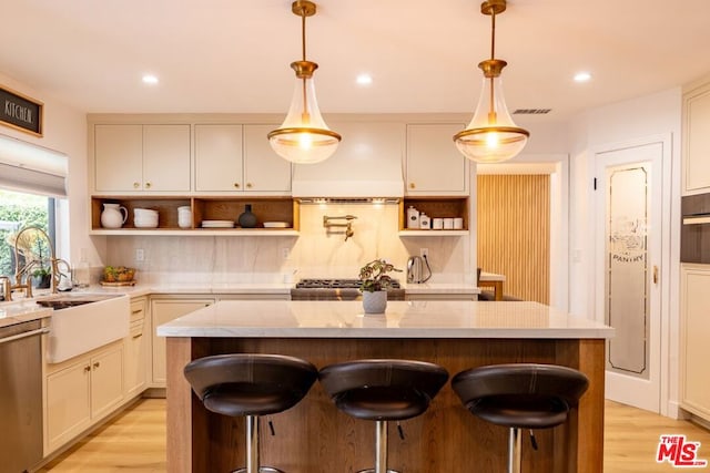 kitchen with hanging light fixtures, stainless steel dishwasher, a center island, and premium range hood