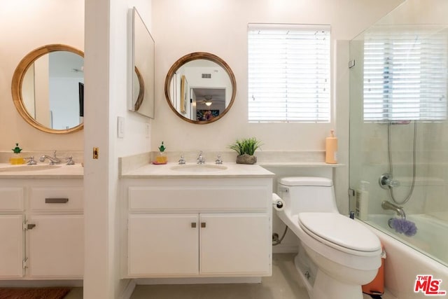 full bathroom featuring enclosed tub / shower combo, vanity, and toilet