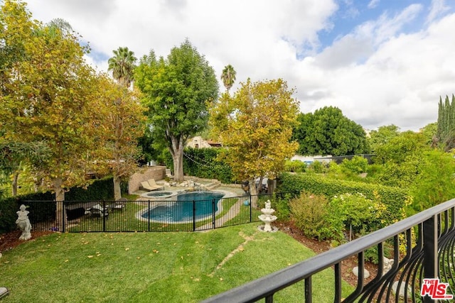 view of swimming pool with a lawn and an in ground hot tub