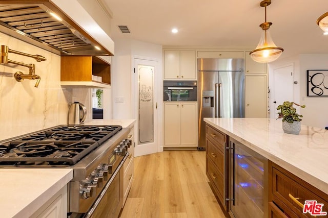 kitchen featuring premium range hood, white cabinetry, hanging light fixtures, high end appliances, and beverage cooler