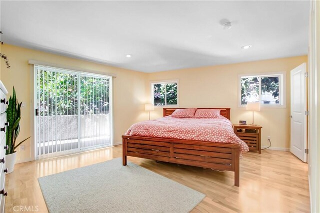 bedroom with access to outside and light wood-type flooring